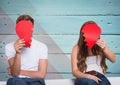 Couple hiding their face behind broken heart Royalty Free Stock Photo