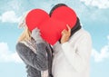 Couple hiding their face behind red heart Royalty Free Stock Photo