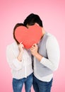 Couple hiding their face behind red heart Royalty Free Stock Photo