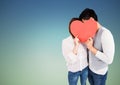 Couple hiding their face behind red heart Royalty Free Stock Photo