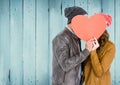 Couple hiding their face behind red heart Royalty Free Stock Photo