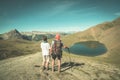 Couple of hiker on the mountain top looking at blue lake and mountain peaks. Summer adventures on the Alps. Wide angle view from a Royalty Free Stock Photo
