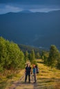 Couple hikers with backpacks holding hands, walking in the mountains Royalty Free Stock Photo