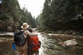 Couple of hikers hugging and looking at the mountain river