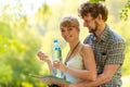 Couple hikers resting in forest drinking water Royalty Free Stock Photo