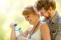 Couple hikers resting in forest drinking water Royalty Free Stock Photo