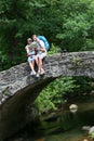 Couple of hikers resting on stone bridge Royalty Free Stock Photo