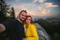 Couple hikers taking a selfie on top of a mountain, summer sunset time. Man and woman looking at beautiful inspirational landscape Royalty Free Stock Photo