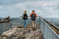 Couple of hikers together enjoying view of nature.Autumn fall outdoor cold season.Man and woman backpackers on viewing platform.