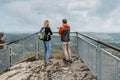 Couple of hikers together enjoying view of nature.Autumn fall outdoor cold season.Man and woman backpackers on viewing platform.