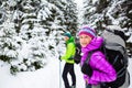 Couple hikers trekking in winter woods