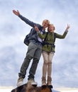 Couple, hiking and excited on mountain top for travel, success and achievement with peace sign on cloudy sky. Portrait Royalty Free Stock Photo