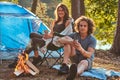 Couple hiking at in the forest. Attractive couple warming near a campfire at camp.