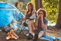 Couple hiking at in the forest. Attractive couple warming near a campfire at camp.