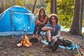 Couple hiking at in the forest. Attractive couple warming near a campfire at camp.