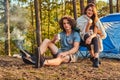 Couple hiking at in the forest. Attractive couple warming near a campfire at camp.