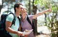 Couple, hiking in nature and map for direction, documents guide or location information of forest travel or journey. Man
