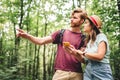 Couple hiking and using maps app on cell phone. Two people hikers looking at mobile phone trying find route. Hike in forest,