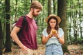 Couple hiking and using maps app on cell phone. Two people hikers looking at mobile phone trying find route. Hike in forest, Royalty Free Stock Photo