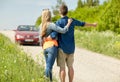 Couple hitchhiking and stopping car on countryside