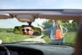 Couple hitchhiking and stopping car on countryside