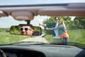 Couple hitchhiking and stopping car on countryside