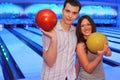 Couple hold balls in bowling club