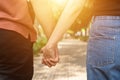 Couple hold hands in the autumn or summer park on sunset. Closeup of loving couple holding hands while walking Royalty Free Stock Photo