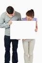 Couple holding banner together and looking down Royalty Free Stock Photo