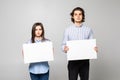 Young couple holding a blank isolated over a white background Royalty Free Stock Photo