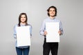 Young couple holding a blank isolated over a white background Royalty Free Stock Photo