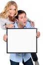 Couple holding blank message board