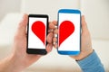 Couple holding cellphone with half heart symbol Royalty Free Stock Photo