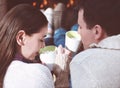 Couple holding cups with hot chocolate with marshmallows