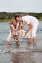 Couple holding dogs over water