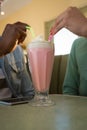 Couple holding drinking straw in milkshake at restaurant Royalty Free Stock Photo