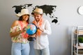 Couple holding a globe with a world map in the background