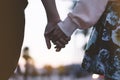 Couple holding for hands on the beach on background ocean sunrise flare, silhouette two romantic people looking on rear view Royalty Free Stock Photo