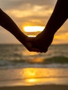 Couple holding hands on beautiful sunset background at the beach Royalty Free Stock Photo