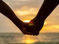 Couple holding hands on beautiful sunset background at the beach Royalty Free Stock Photo