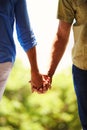 Couple, holding hands and bonding together in nature for romance and commitment in healthy relationship in outdoor