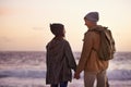 Couple, holding hands and love at sunset by beach, ocean waves and peace for romance in relationship. People, back and Royalty Free Stock Photo