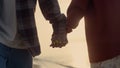 Couple holding hands at sea beach. Loving girl and guy walking along ocean shore Royalty Free Stock Photo