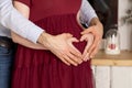 Couple holding hands in the shape of heart on pregnant belly. Royalty Free Stock Photo