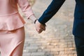 couple holding hands tightly, walk on the cobbled path. Royalty Free Stock Photo