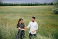 Couple holding hands and walking in a green flowers field Royalty Free Stock Photo