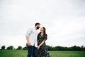 Couple holding hands and walking in a green flowers field Royalty Free Stock Photo