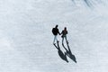 Couple holding hands and walking on the street with shadows on the ground Royalty Free Stock Photo