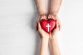 Couple holding heart with cross symbol on background, top view. Christian religion Royalty Free Stock Photo