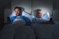 Couple Holding Mobile Phones In Bedroom Royalty Free Stock Photo